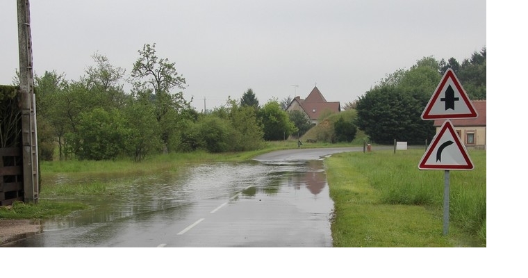 La route qui traverse le bourg est innondée à la sortie du village.